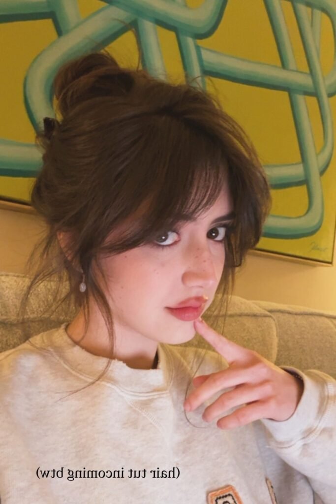 2. (High Messy Bun with Soft Curtain Bangs and Face-Framing Strands)
