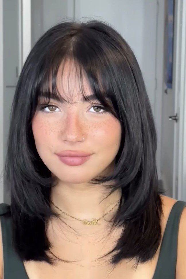1. Dark Mid-Length Cut with Wispy Bangs and Face-Framing Layers