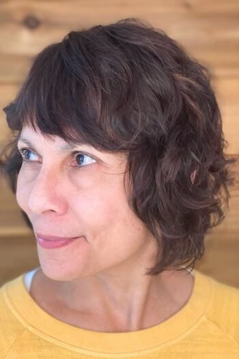 10. Dark Brown Wavy Shag Bob with Brow-Grazing Bangs