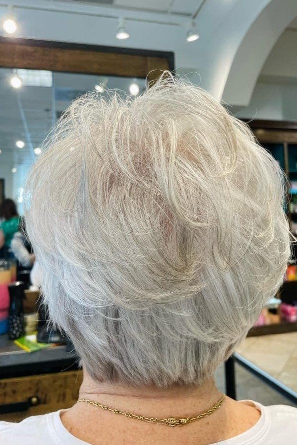 11. Layered Silver Pixie Cut with Feathery Crown Volume