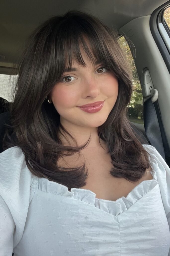 13. Shoulder-Length Soft Layered Cut with Straight-Across Bangs