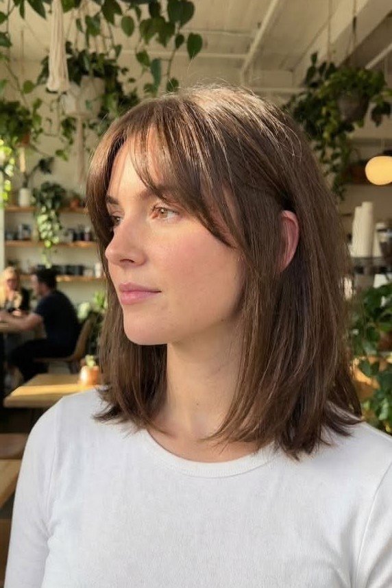 14. Straight Shoulder-Length Cut with Soft Wispy Bangs