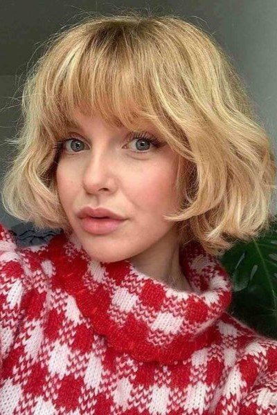 15. Wavy Blonde French Bob with Fluffy Full Bangs