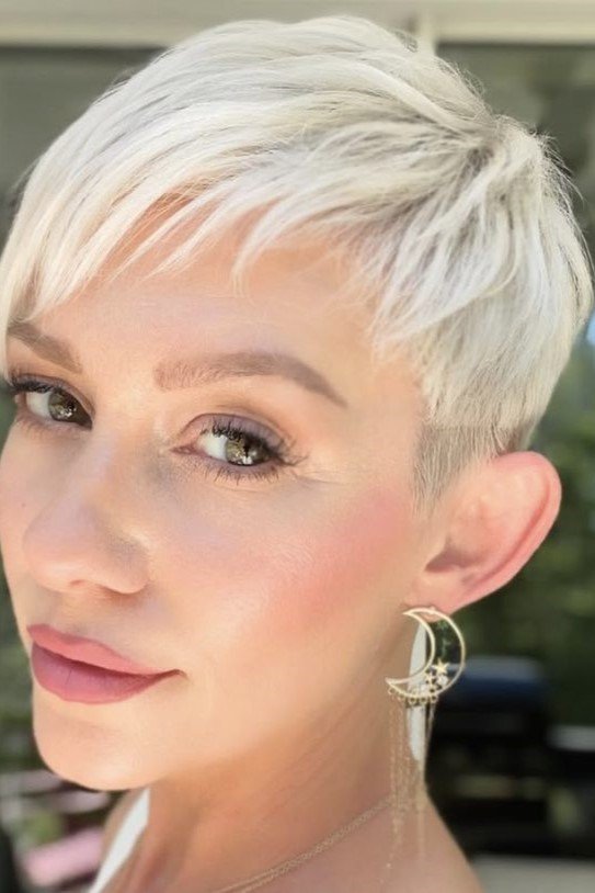 17. Sleek Platinum Blonde Pixie with Side-Swept Fringe and Tapered Sides