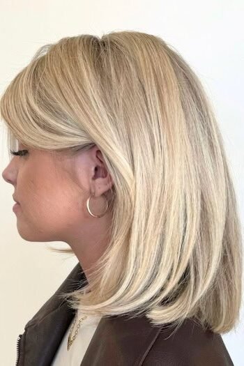 17. Smooth Creamy Blonde Lob with Side-Swept Bangs