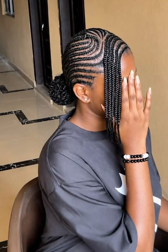 2. Curved Stitch Braids with Low Braided Bun and Side Bangs