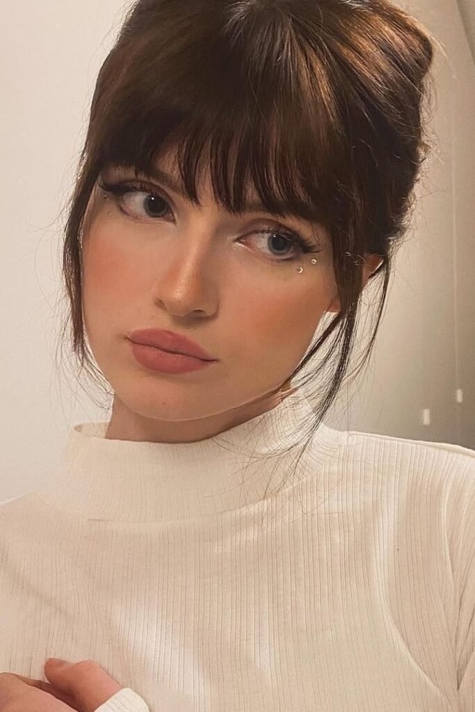 7. Retro Elegant Updo with Classic Full Fringe Bangs