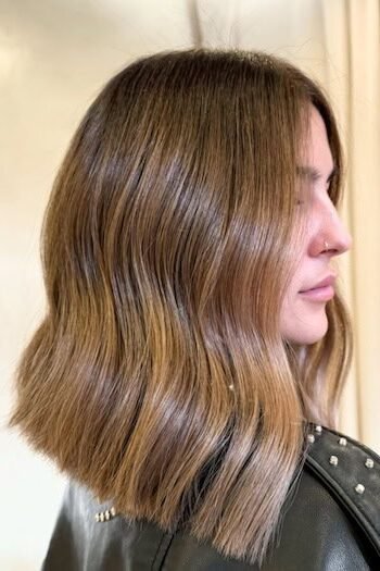 8. Glossy Warm Caramel Wavy Lob