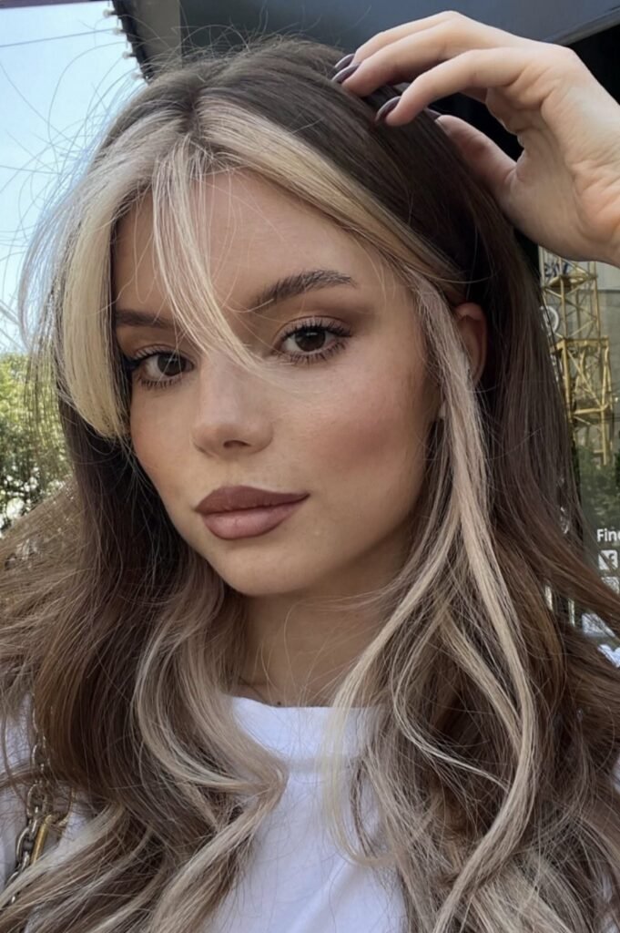 9. Long Wavy Brunette Hair with Curtain Bangs and Blonde Money Piece
