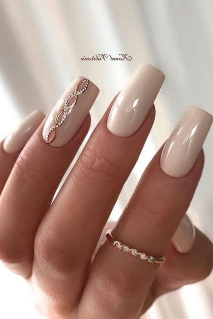 10. Creamy Beige Nails with Rose Gold Crystal Swirl