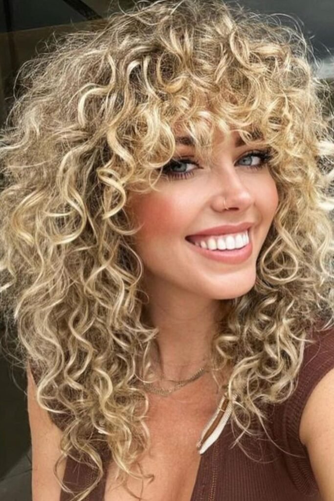 6. Honey Blonde Spiral Curl Shag with Curly Bangs