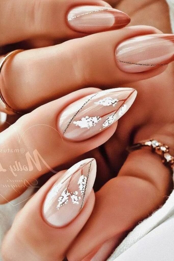 5. Nude Almond Nails with White Floral Sprigs and Gold Lines