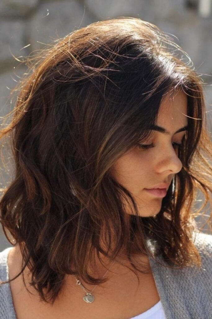15. Messy Brunette Lob with Caramel Highlights