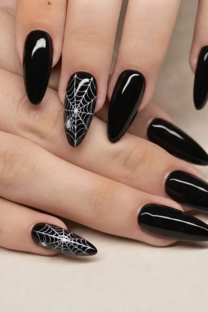 4. Glossy Black Nails with White Spiderweb Accents