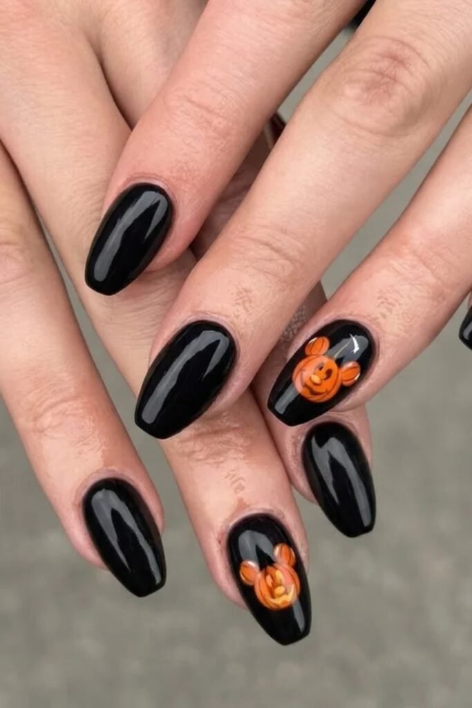 9. Glossy Black Nails with Round-Eared Pumpkin Accents