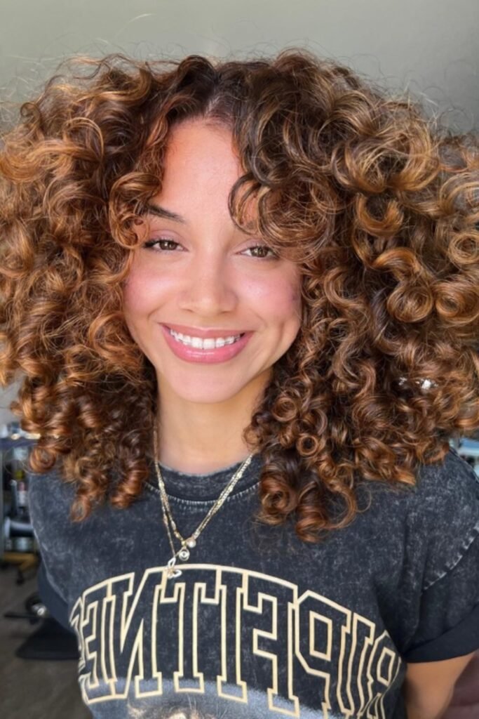 10. Caramel Copper Highlights on Chestnut Curls