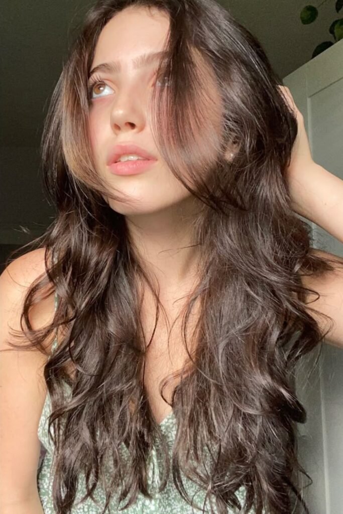10. Dark Layered Waves with Wispy Face Framing